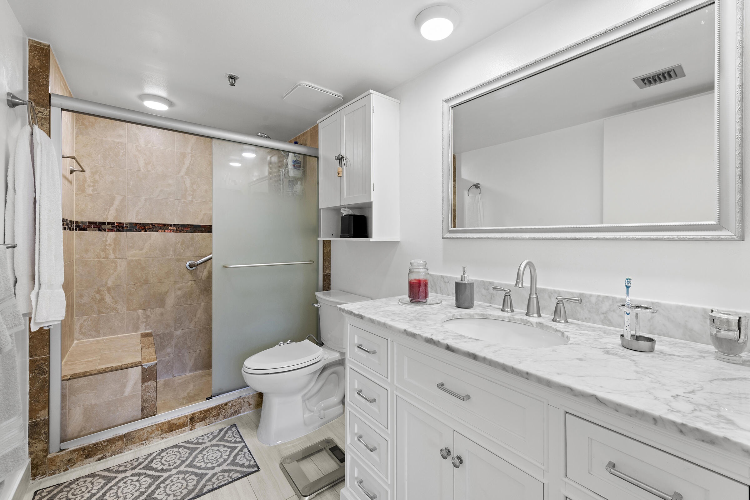 6845 Willow Wood Drive, Unit 3012 Boca Raton, FL 33434 - Photo 13 of 28 a bathroom with a granite countertop sink toilet and shower