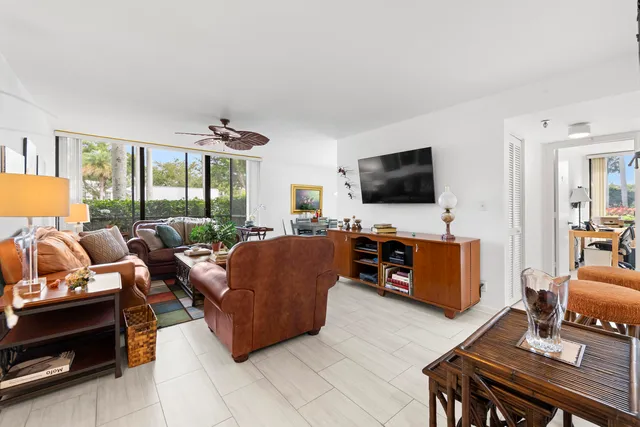 a living room with furniture a flat screen tv and a floor to ceiling window