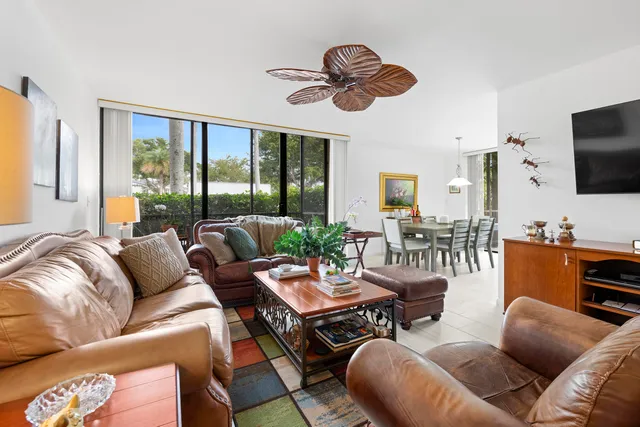 a living room with furniture a floor to ceiling window and a flat screen tv