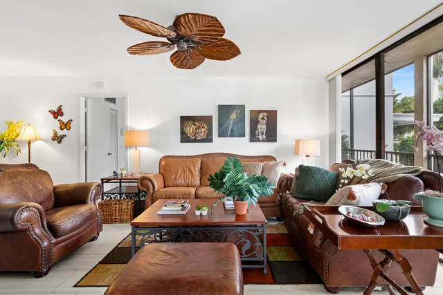 a living room with furniture potted plant and a large window