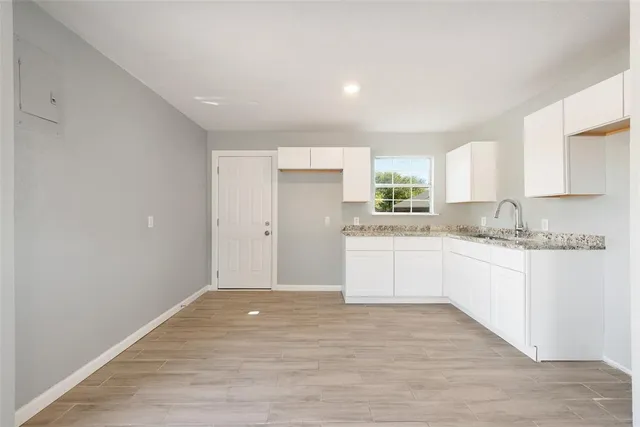 a kitchen with granite countertop white cabinets and white appliances