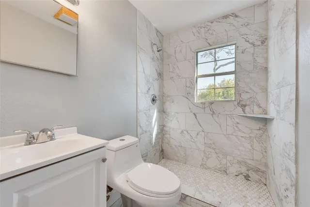 a bathroom with a sink toilet and shower