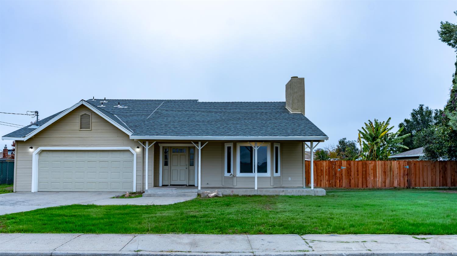 12501 Riverside Road Waterford, CA 95386 - Photo 1 of 24 a front view of a house with a yard and garage