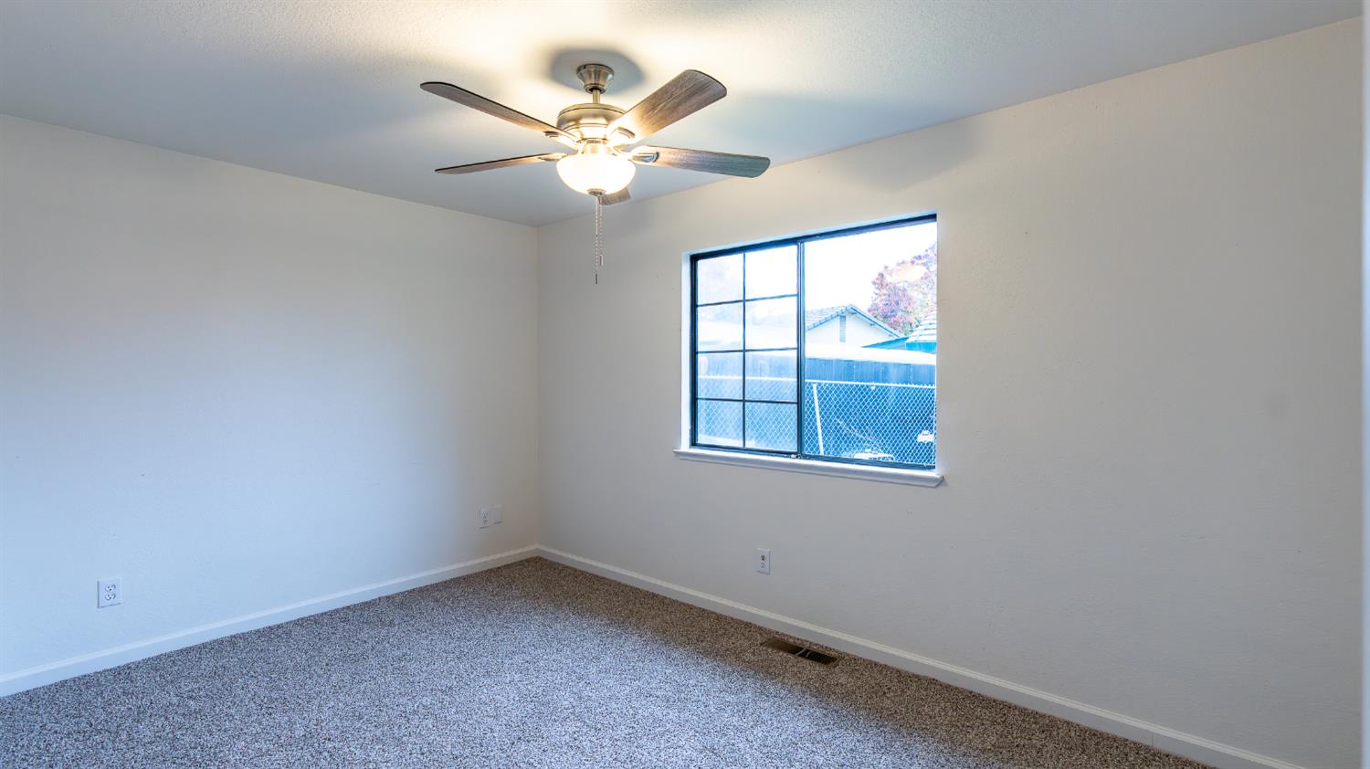 12501 Riverside Road Waterford, CA 95386 - Photo 14 of 24 an empty room with windows and fan