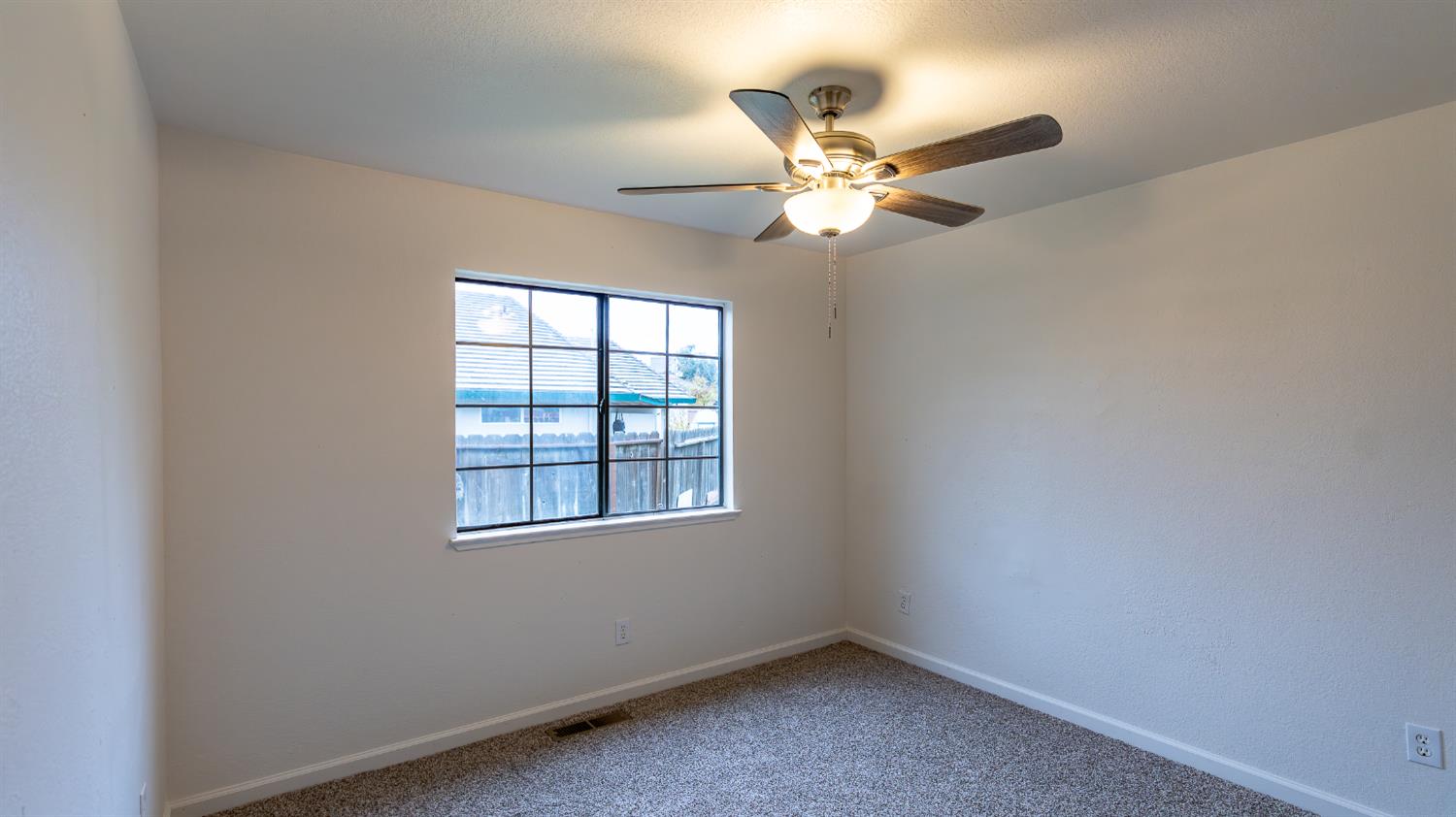 12501 Riverside Road Waterford, CA 95386 - Photo 15 of 24 an empty room with windows and fan