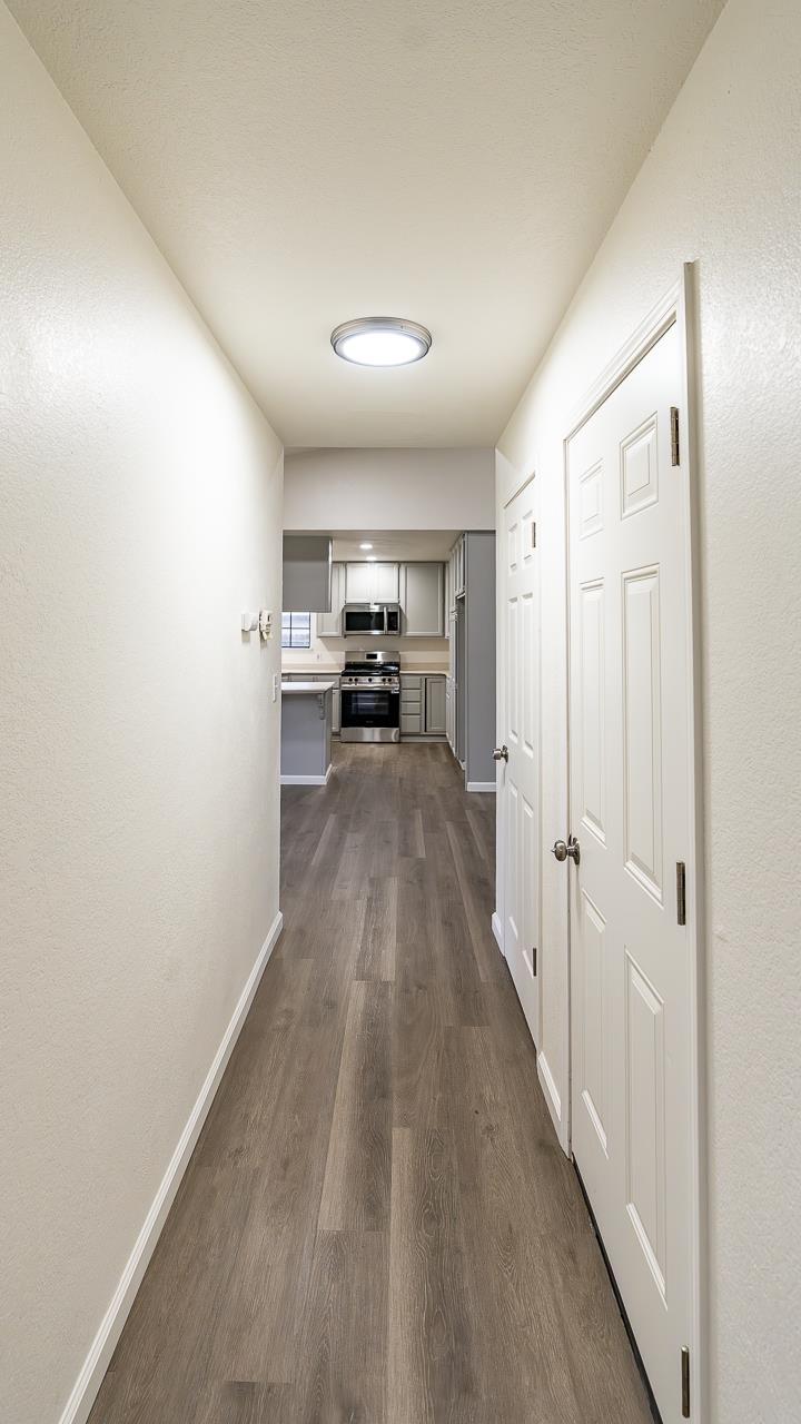 12501 Riverside Road Waterford, CA 95386 - Photo 16 of 24 a view of a hallway to a livingroom with wooden floor and furniture