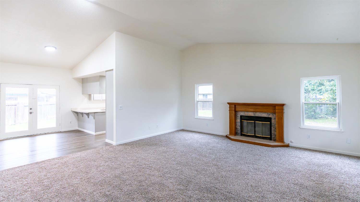 12501 Riverside Road Waterford, CA 95386 - Photo 3 of 24 an empty room with a fireplace and windows