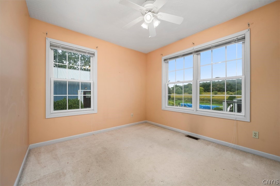 1322 Sawmill Road Sangerfield, NY 13480 - Photo 33 of 50 Double-hung windows frame pleasant backyard views from this carpeted bedroom.