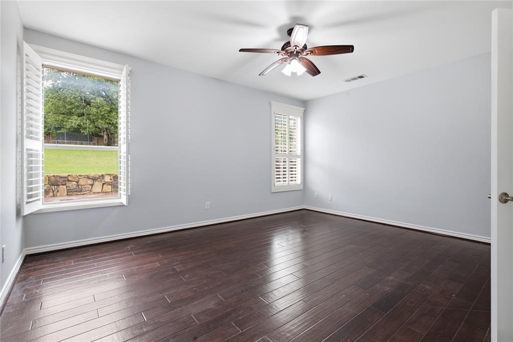 10001 Thurman Road Fort Worth, TX 76244 - Photo 17 of 40 Spacious room featuring dark wood-finish flooring, light gray wall tones, and white window shutters
