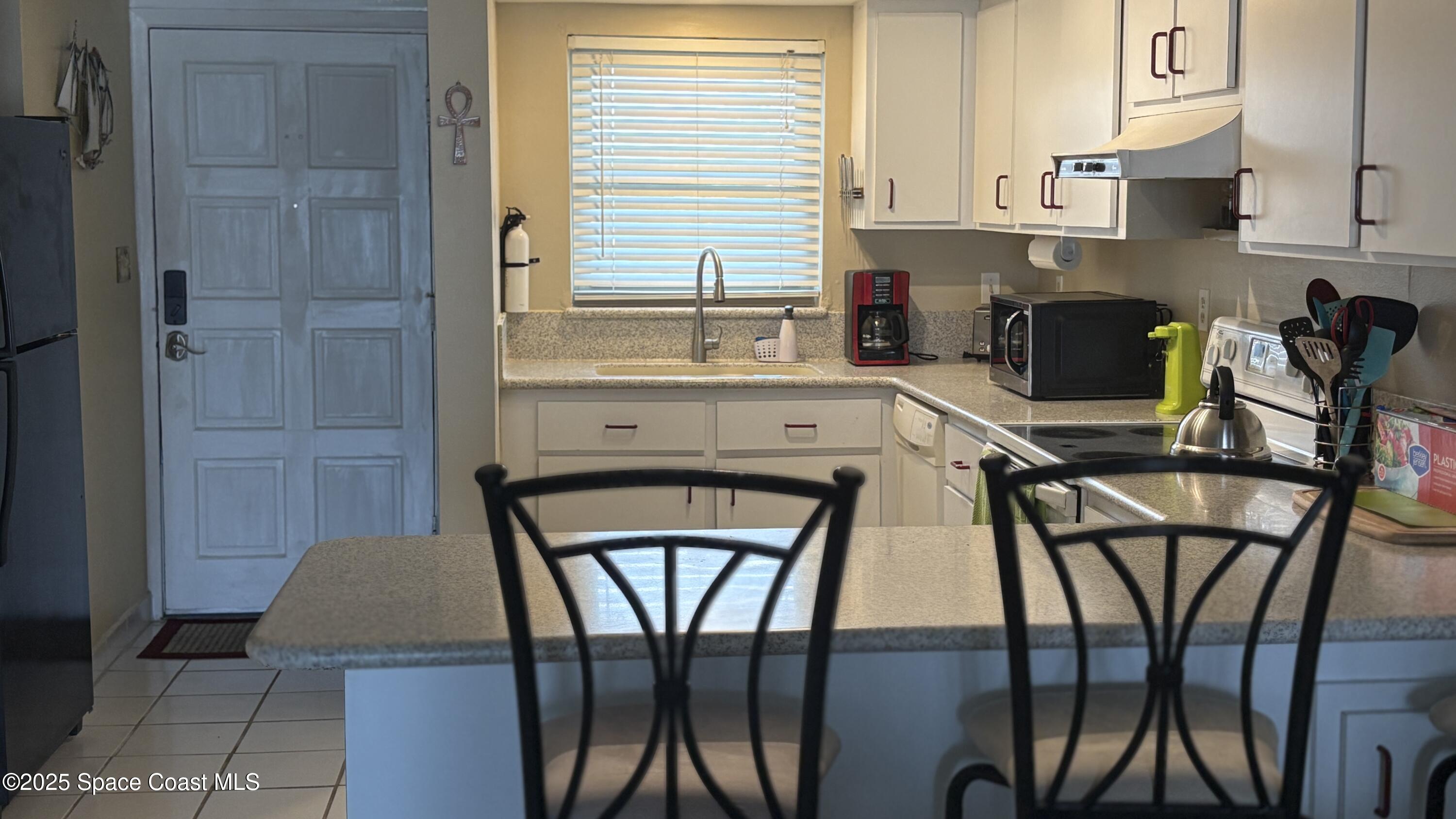 Undisclosed Address Cocoa Beach, FL 32931 - Photo 3 of 17 a kitchen with stainless steel appliances a table and chairs in it