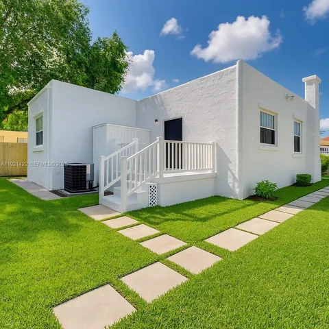 a backyard of a house with table and chairs