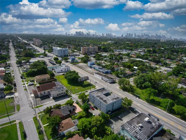 an aerial view of a city with lots of residential buildings ocean and mountain view in back