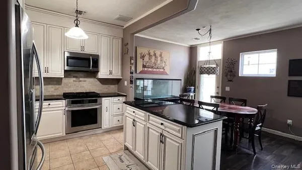 a kitchen with granite countertop a sink stove and refrigerator