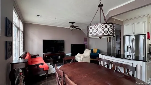 a living room with furniture a flat screen tv and a chandelier