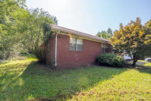 a view of a house with a yard and potted plants