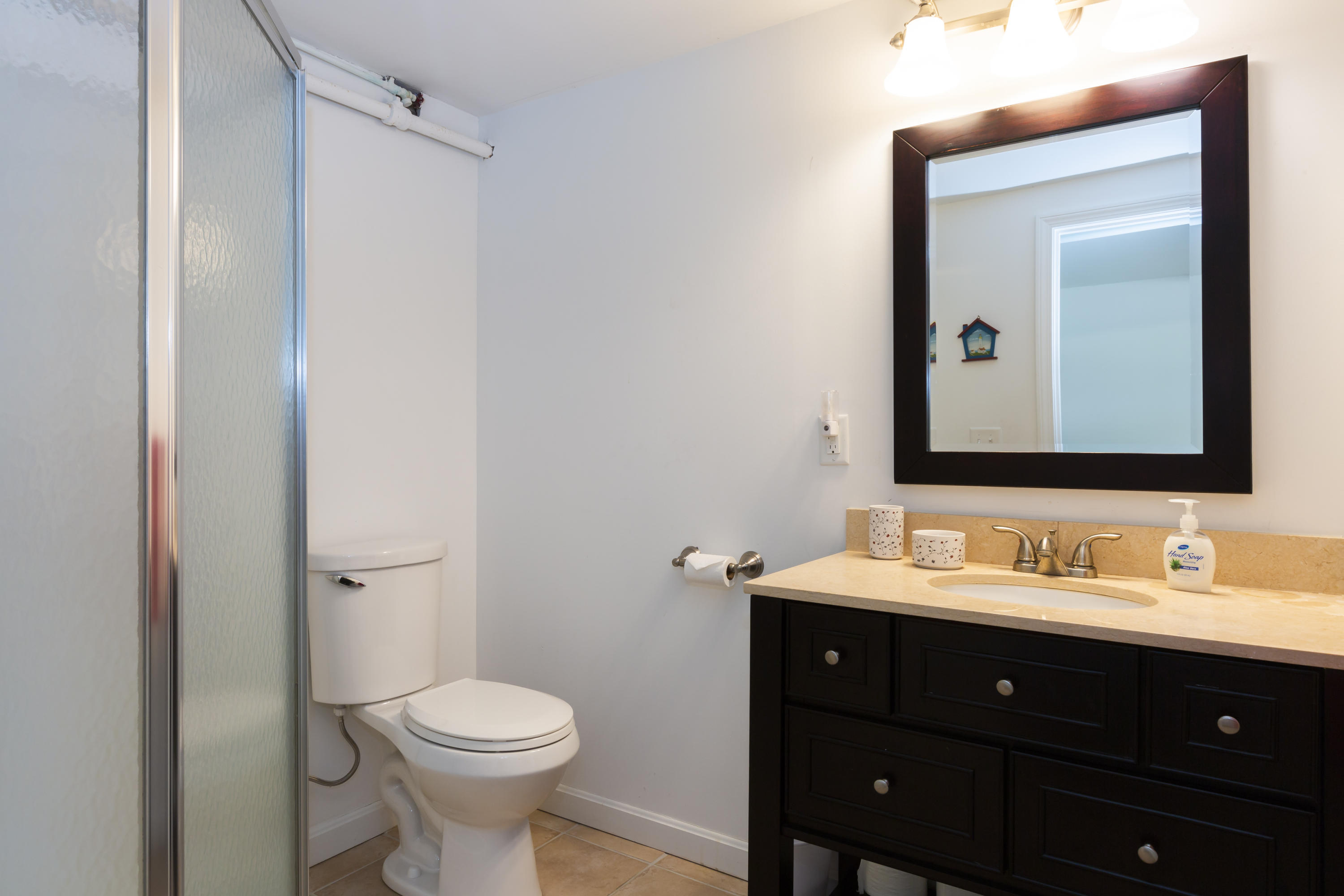 307 Shore Road, Unit 9 & SB2 Truro, MA 02666 - Photo 11 of 13 a bathroom with a toilet sink and mirror