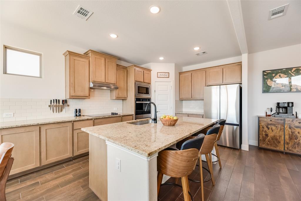 561 Randys Way Pilot Point, TX 76258 - Photo 2 of 34 a kitchen with stainless steel appliances granite countertop a table chairs sink refrigerator and cabinets