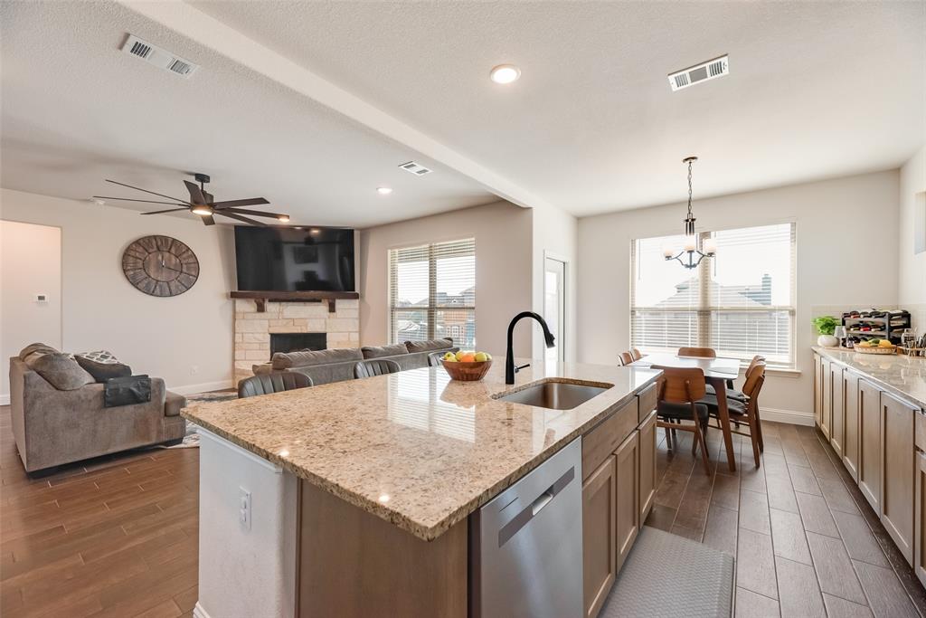 561 Randys Way Pilot Point, TX 76258 - Photo 3 of 34 a kitchen with sink refrigerator dining table and chairs