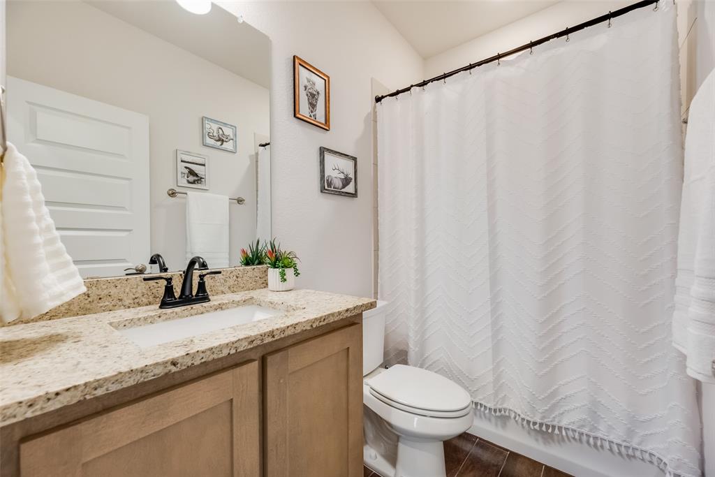 561 Randys Way Pilot Point, TX 76258 - Photo 8 of 34 a bathroom with a granite countertop sink and a mirror