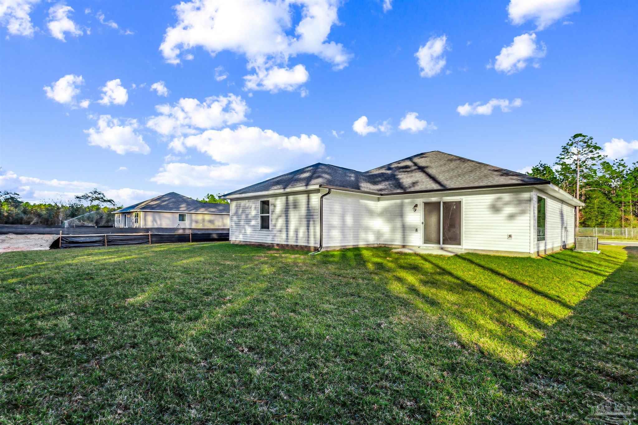 5009 Rainwater Road Milton, FL 32583 - Photo 21 of 29 a view of a white house next to a yard with big trees