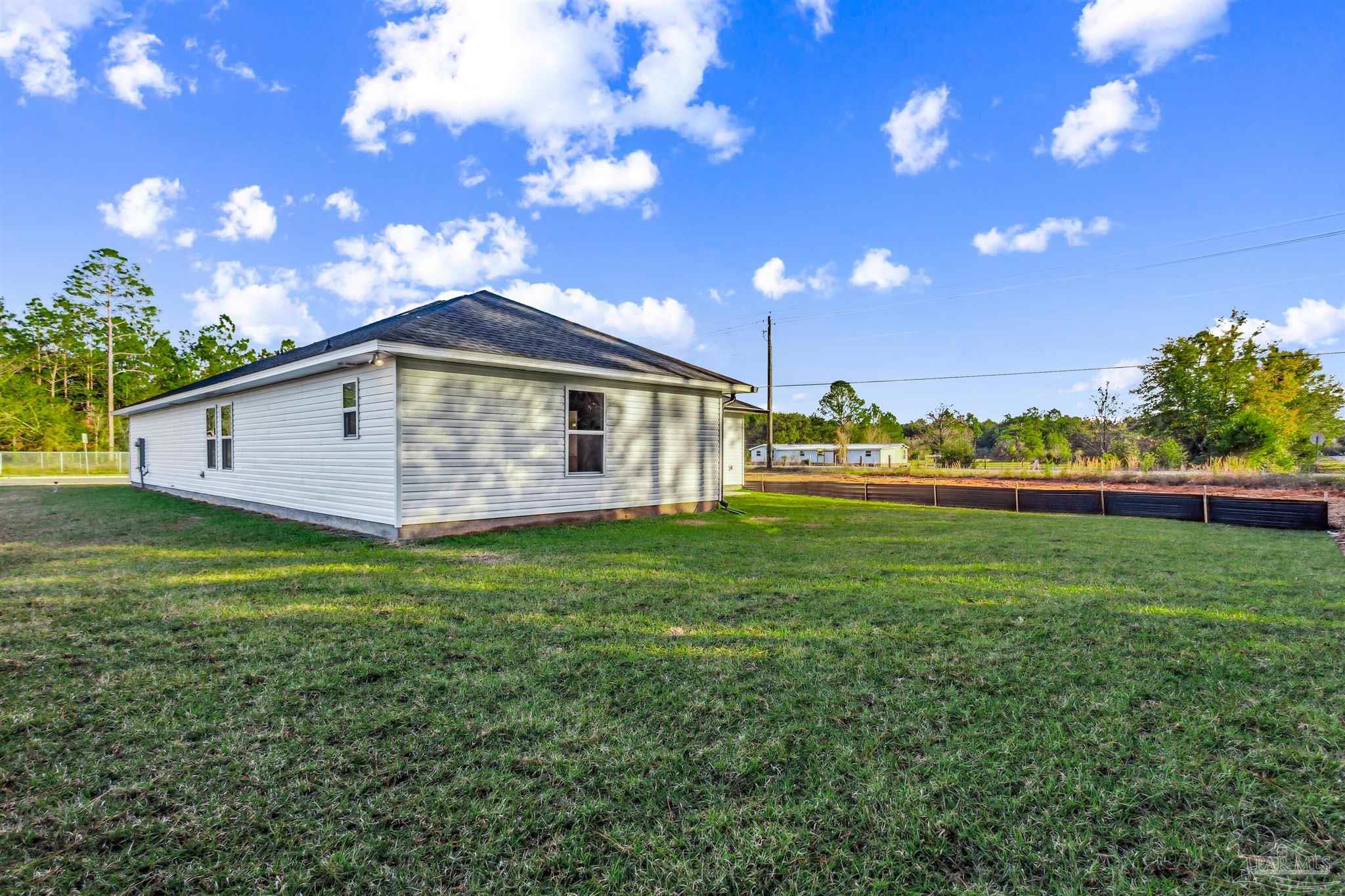 5009 Rainwater Road Milton, FL 32583 - Photo 23 of 29 a view of a house with a backyard and a tree