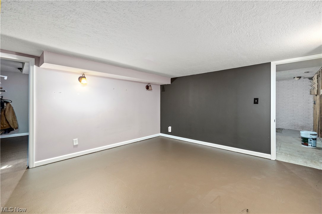 41511 Russia Road Elyria, OH 44035 - Photo 29 of 33 Spare room with a textured ceiling, concrete floors, and brick wall