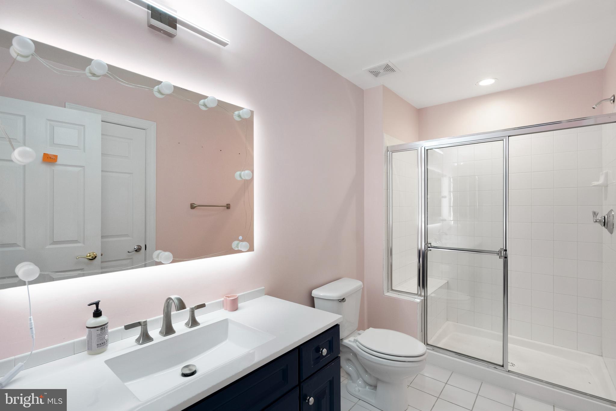 818 Hidden Bluff Circle Catonsville, MD 21228 - Photo 21 of 36 a bathroom with a sink a toilet and a large mirror