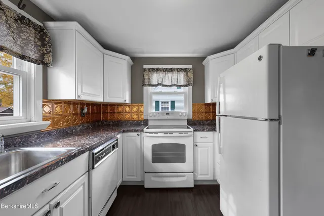 a kitchen with stainless steel appliances granite countertop a refrigerator sink and stove