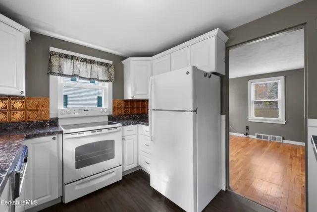 a white refrigerator freezer and a stove sitting inside of a kitchen