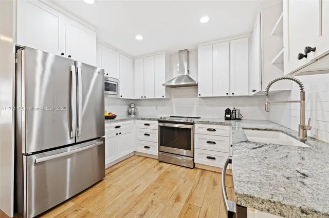 a kitchen with stainless steel appliances a refrigerator sink and cabinets