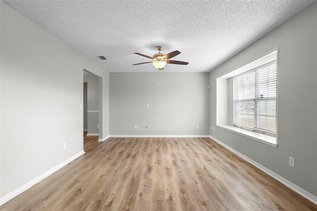 1031 Abeline Drive Deltona, FL 32725 - Photo 11 of 37 wooden floor in an empty room with a window