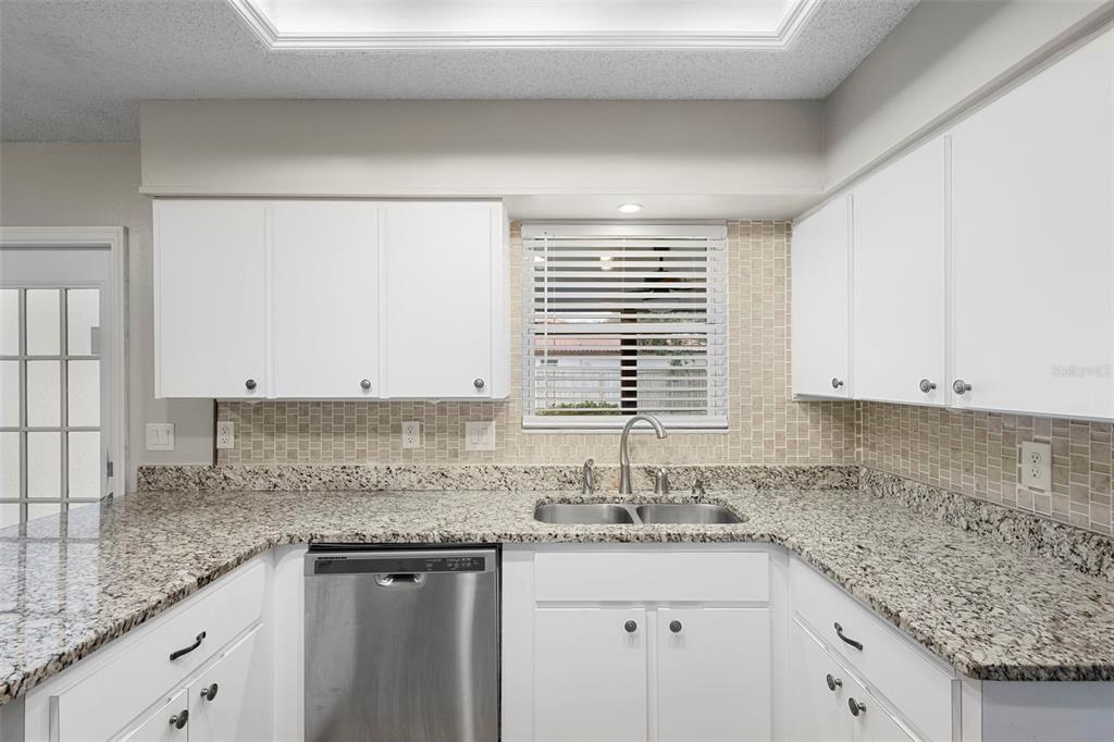 1031 Abeline Drive Deltona, FL 32725 - Photo 18 of 37 a kitchen with granite countertop a sink and a white cabinets