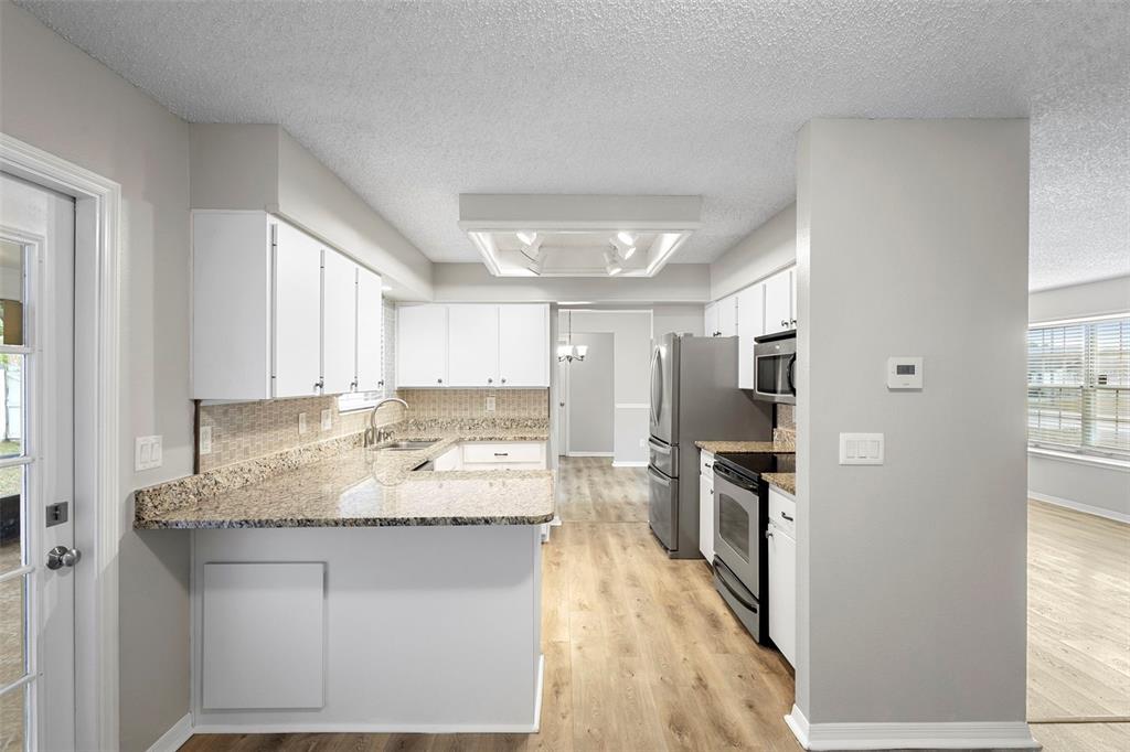 1031 Abeline Drive Deltona, FL 32725 - Photo 19 of 37 a kitchen with stainless steel appliances granite countertop a sink stove and refrigerator