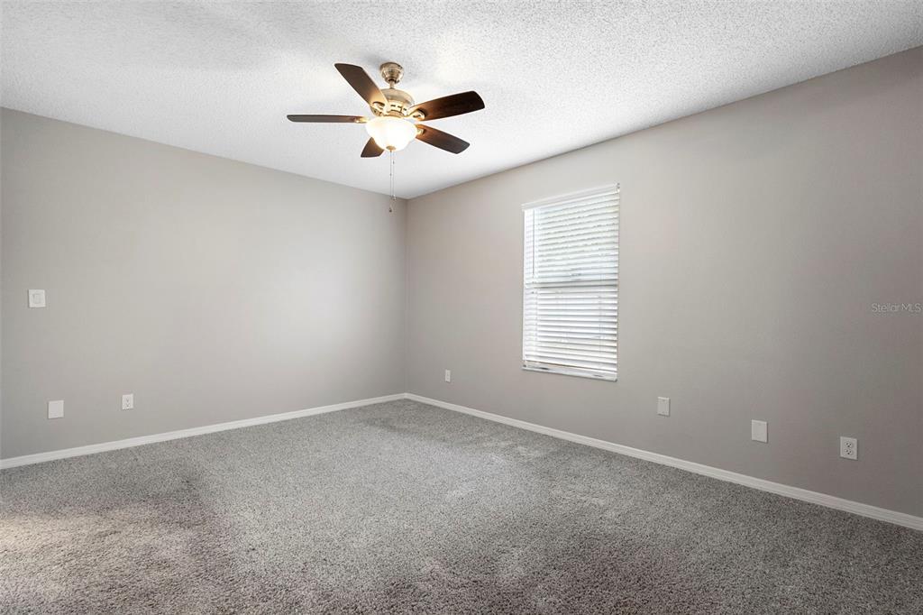 1031 Abeline Drive Deltona, FL 32725 - Photo 25 of 37 an empty room with windows and fan