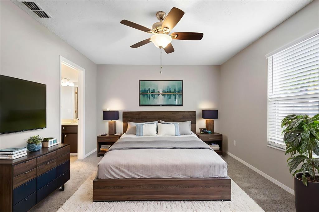 1031 Abeline Drive Deltona, FL 32725 - Photo 5 of 37 a bedroom with a large bed and a flat screen tv