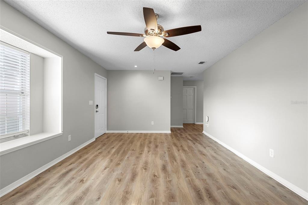 1031 Abeline Drive Deltona, FL 32725 - Photo 8 of 37 wooden floor in an empty room with a window