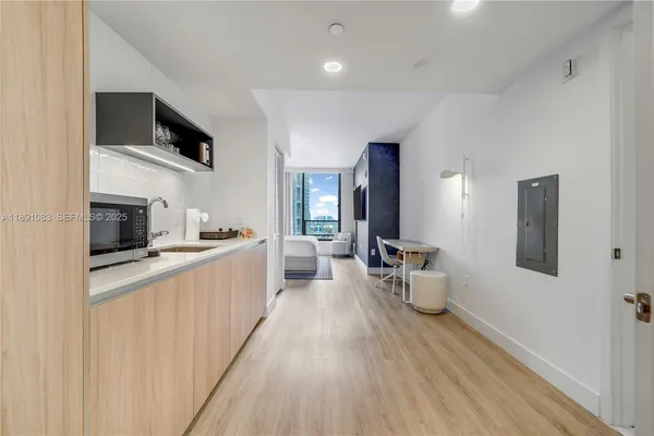 a large kitchen with a lot of counter space and wooden floor
