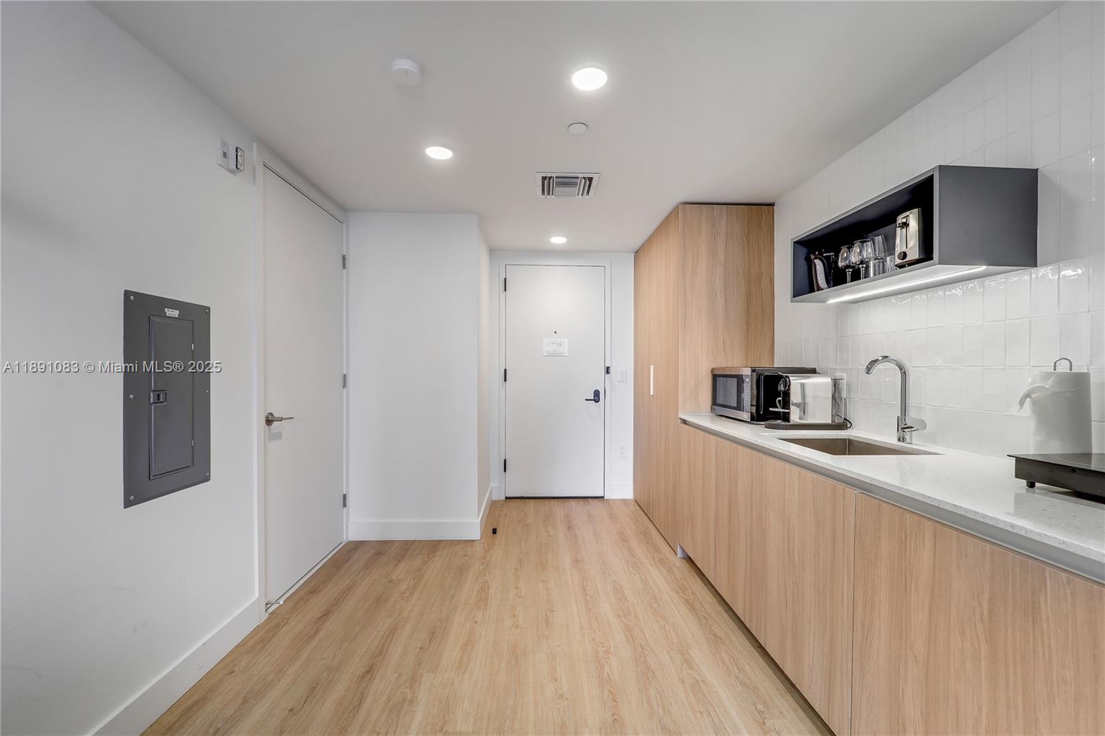 601 Northeast 1st Avenue, Unit 1619 Miami, FL 33132 - Photo 6 of 17 a view of a kitchen with a sink and wooden floor