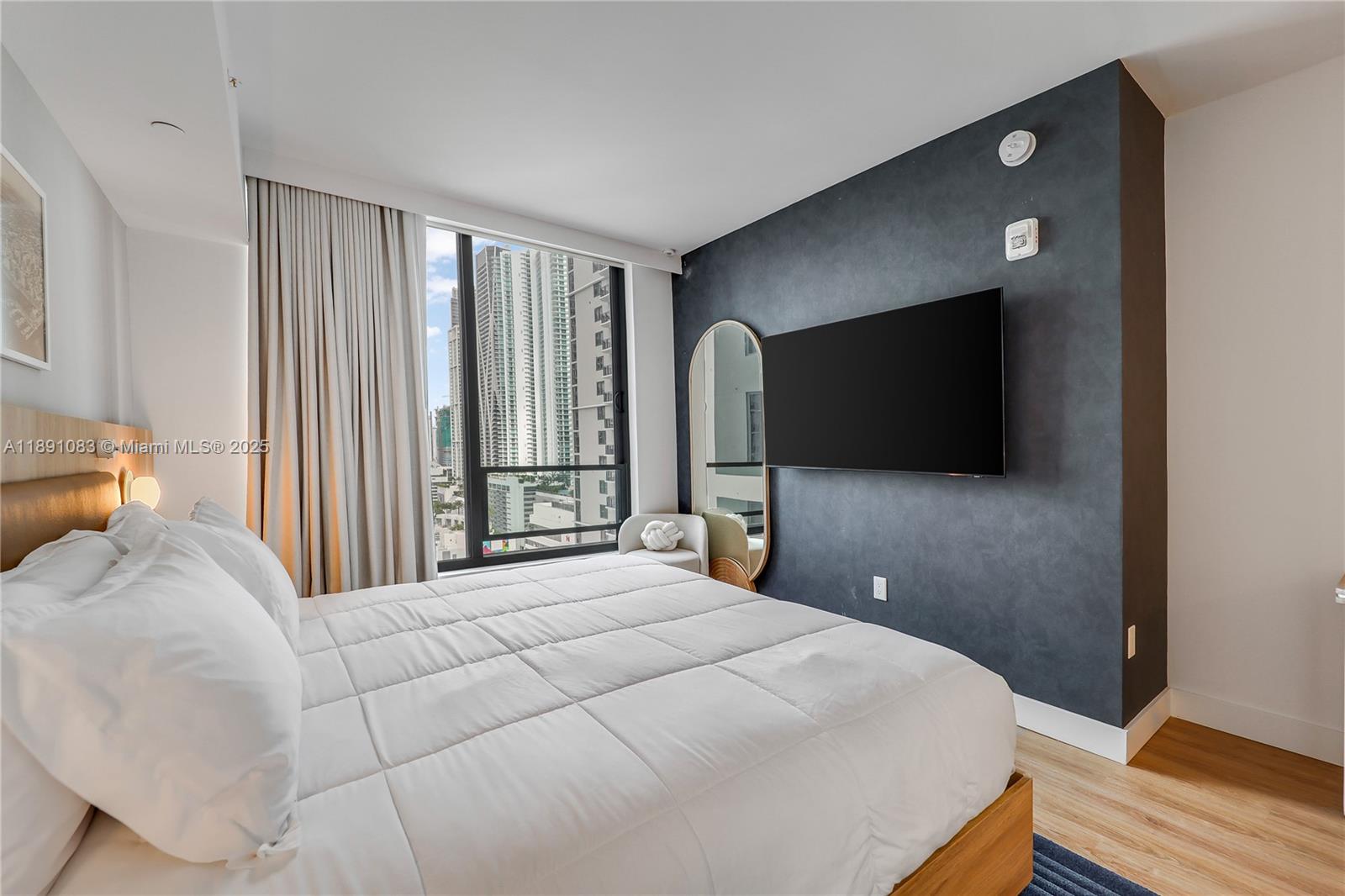 601 Northeast 1st Avenue, Unit 1619 Miami, FL 33132 - Photo 9 of 17 a bedroom with a bed and a flat screen tv