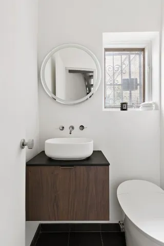 a bathroom with a sink toilet and mirror