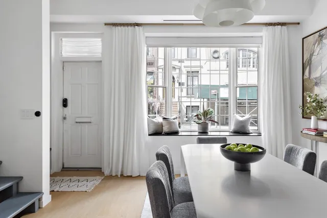 a view of a dining room with furniture a chandelier and wooden floor