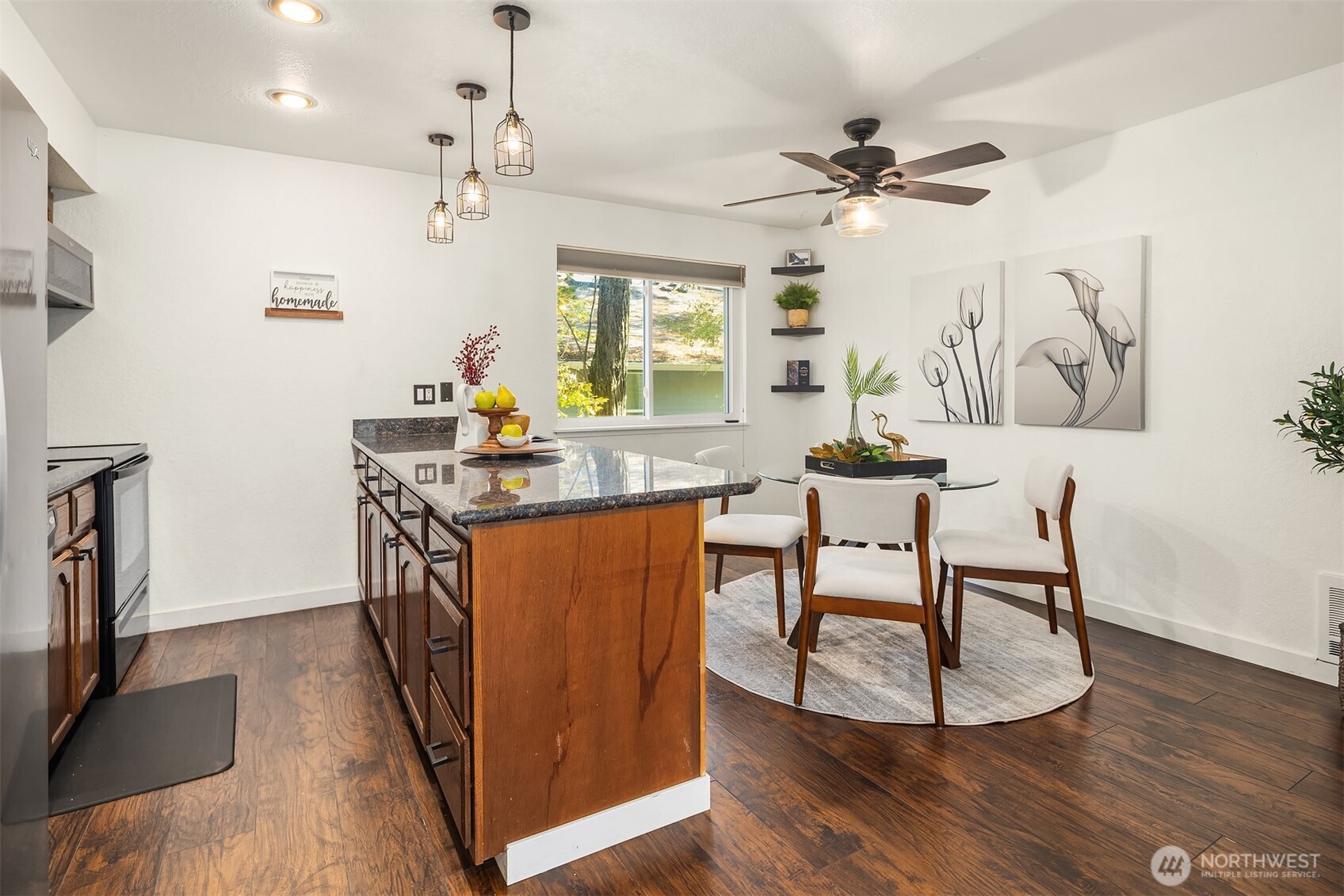 8603 244th Street Southwest, Unit 2D Edmonds, WA 98026 - Photo 5 of 21 a dining room with wooden floor a chandelier a wooden table and chairs