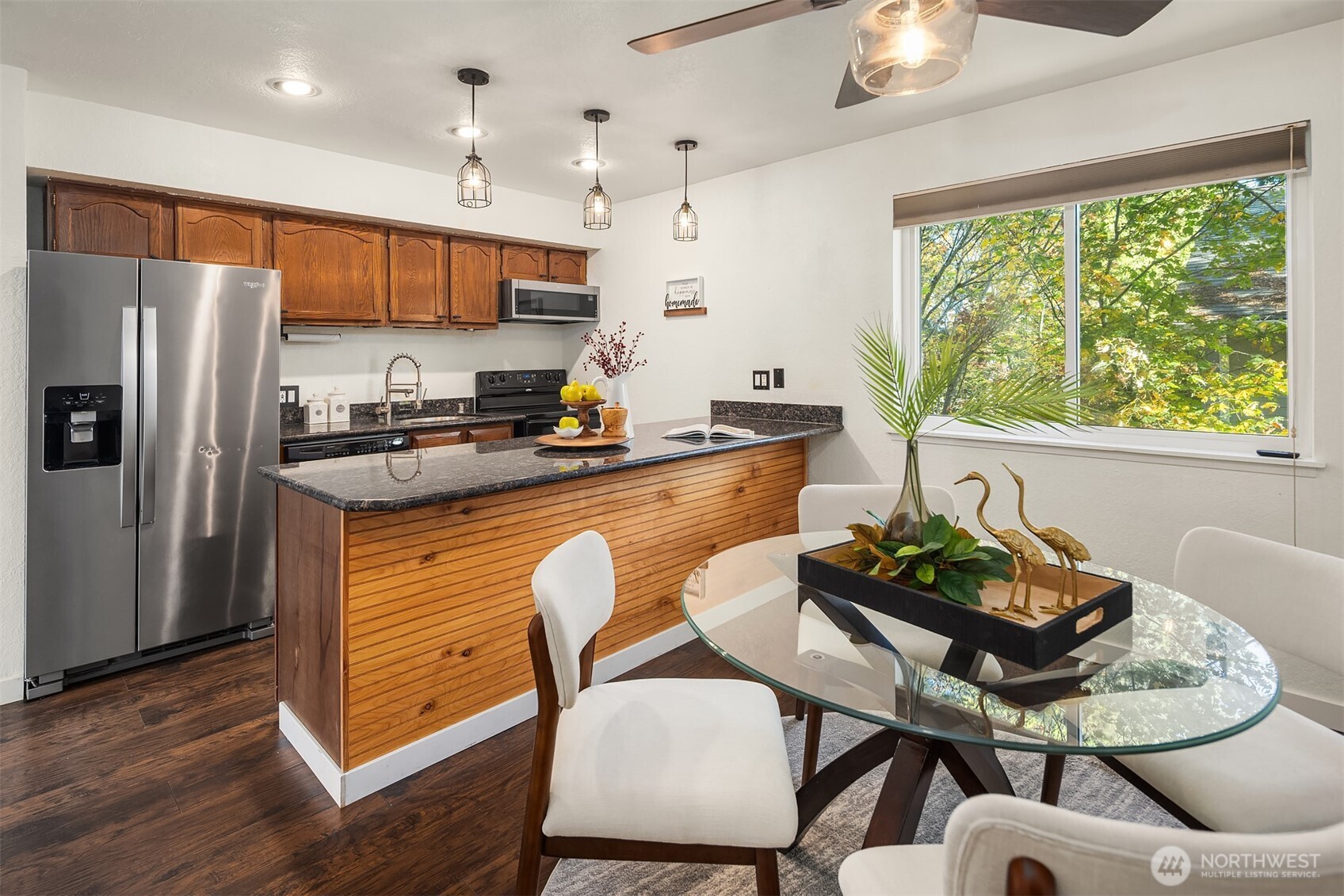 8603 244th Street Southwest, Unit 2D Edmonds, WA 98026 - Photo 7 of 21 a kitchen with stainless steel appliances granite countertop a stove a refrigerator a kitchen island a table and chairs