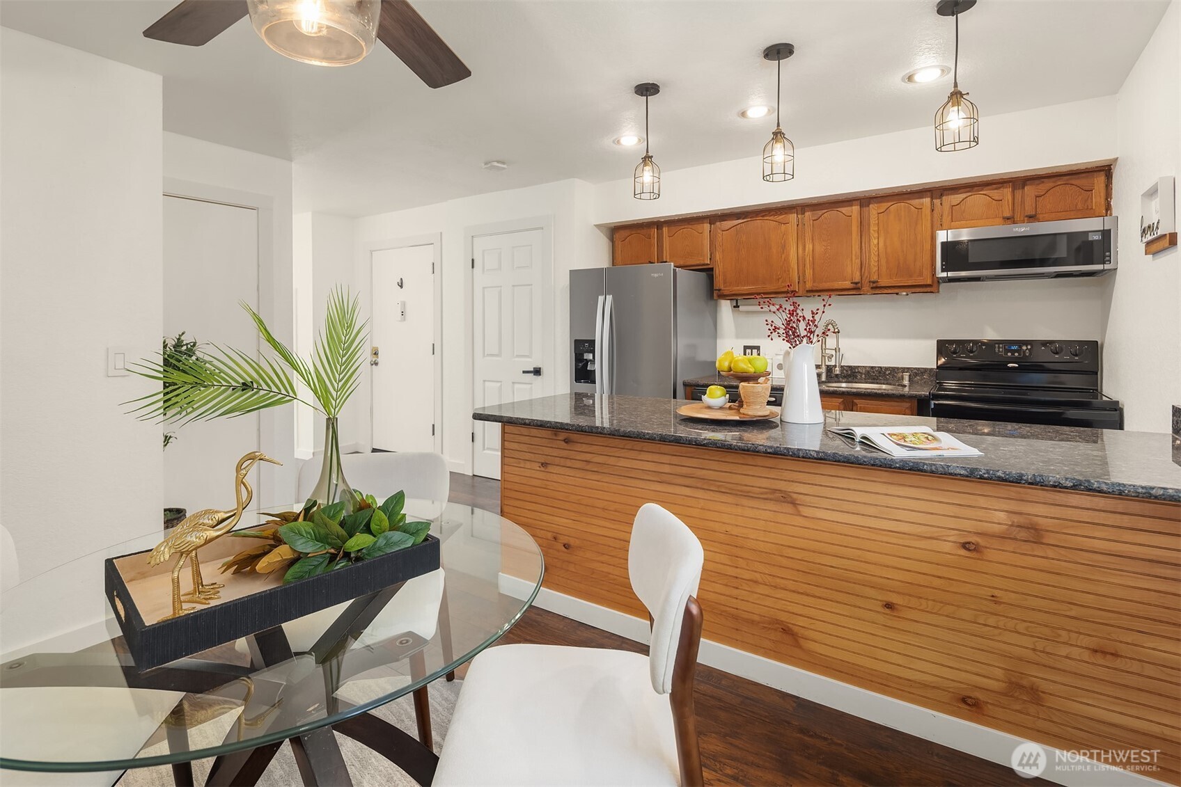 8603 244th Street Southwest, Unit 2D Edmonds, WA 98026 - Photo 9 of 21 a kitchen with stainless steel appliances granite countertop a white table chairs and a refrigerator