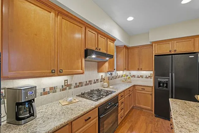 a bathroom with a granite countertop sink a toilet and mirror