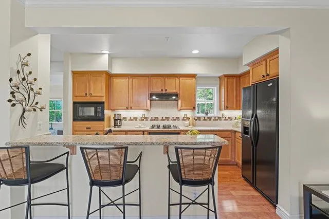 a bathroom with a tub sink double vanity granite and mirror