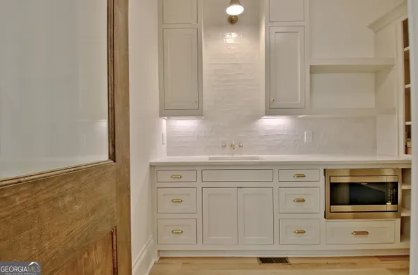 a kitchen with white cabinets and white appliances