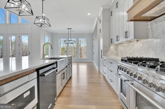a large kitchen with stainless steel appliances granite countertop a lot of counter space and wooden floors