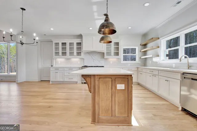 a large kitchen with stainless steel appliances granite countertop a sink and cabinets