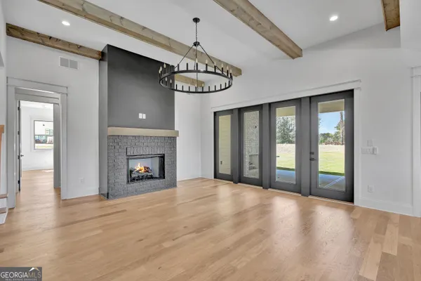 a view of an empty room with a window and fireplace